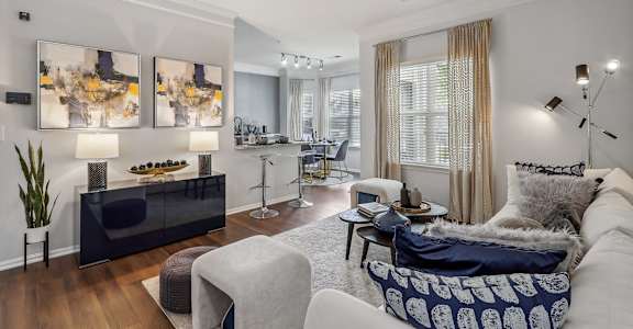 a living room with a couch and chairs and a dining room table