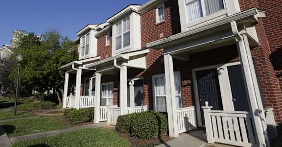 A red brick house with white trim and a porch.