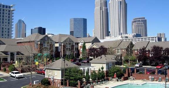 A cityscape with tall buildings and a swimming pool in the foreground.