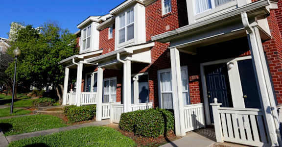 A red brick house with white trim and a porch.