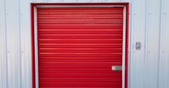 a red garage door in front of a white building