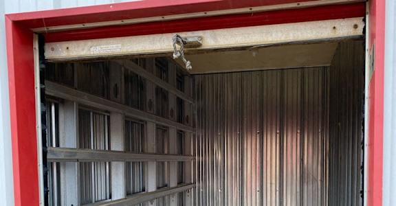 A red and white garage door is open.