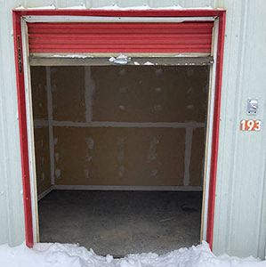 an open garage door with snow on the floor