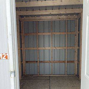 an empty room with shelving in a room with a door