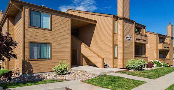 A modern house with a brown facade and a blue sky in the background.