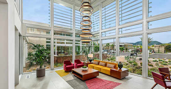A modern living room with a spiral staircase and a view of the outdoors.