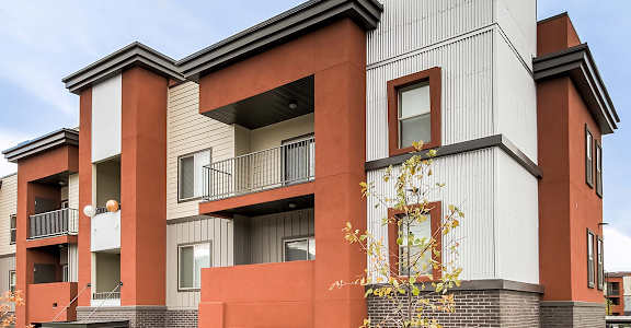 a row of townhomes with orange and white facades