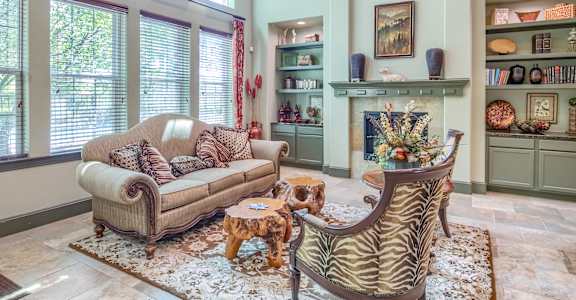 A living room with a zebra print chair and a tan couch.