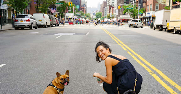 a woman and her dog in the middle of the street