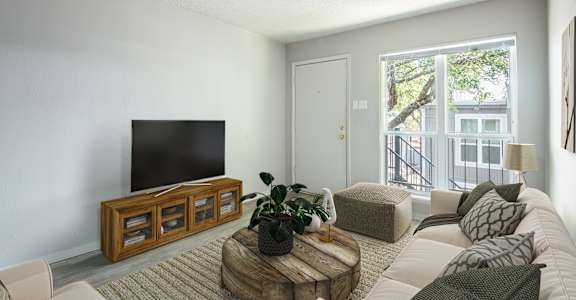 A living room with a flat screen TV and a white couch.
