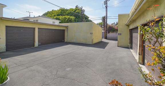 the driveway is between two buildings with garages