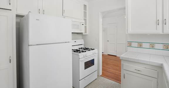 a white kitchen with white appliances and white cabinets