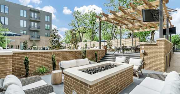 A patio with a fire pit and seating area.