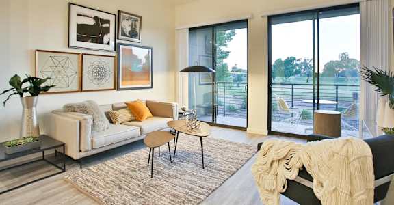 a living room with a couch and a chair and sliding glass doors