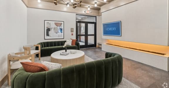 A modern waiting room with a green velvet sofa and a coffee table.