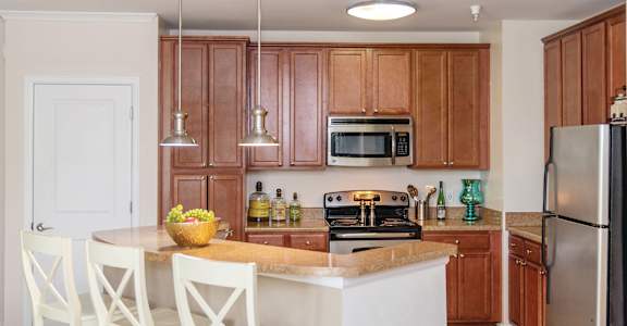 Kitchen with wooden cabinets at River House Apartments, Norfolk, VA, 23504