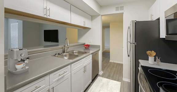 a kitchen with white cabinets and stainless steel appliances at Southaven Pointe Apartments, Mississippi