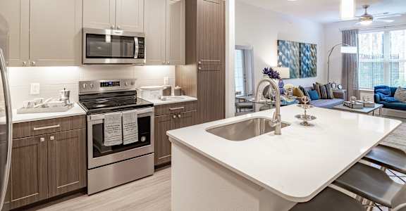 A modern kitchen with a white countertop and stainless steel appliances at Stone Loch Apartments,Texas 77375