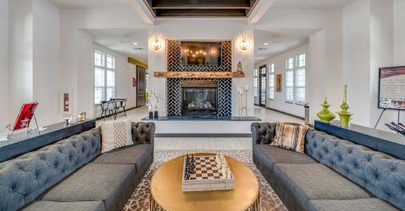 A living room with a fireplace and a grey couch at Waterstone at Hamburg Apartments, Lexington