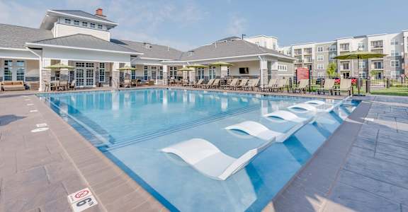A large swimming pool with a building in the background at Waterstone at Hamburg Apartments, Lexington, 40509