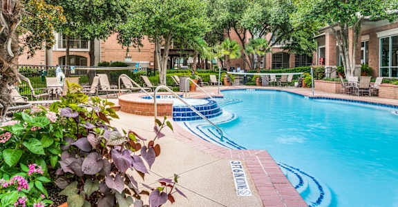 Apartments in North Dallas for Rent-Sparkling Swimming Pool With Volleyball Net Surrounded by Lounge Chairs and Seating