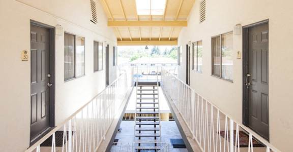 A long hallway with a skylight above and doors on both sides.