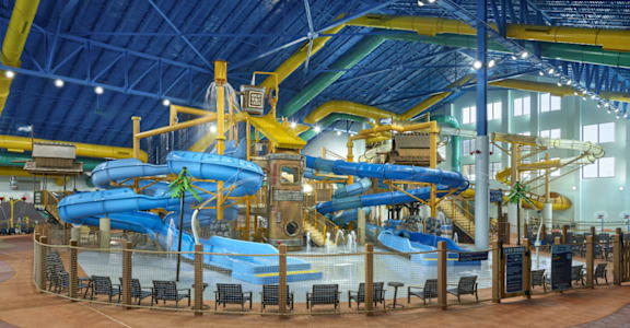 A large indoor water park with a blue and yellow slide. at The Teale Golden Gate in Naples, FL, 34116