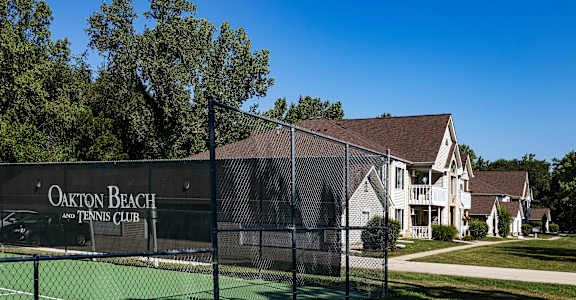 a fence with a tennis court in front of a house
