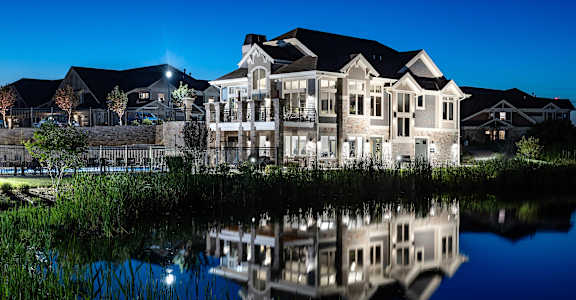 a large building reflected in a pond at night