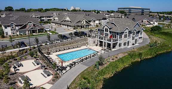 an aerial view of a house with a swimming pool in front of other houses