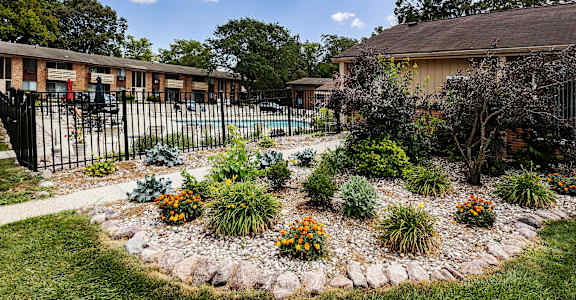 the front yard of a house with a garden and a fence