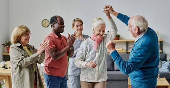 a group of seniors giving each other a high five in a living room at 55+ FountainGlen Temecula, Temecula, CA, 92591