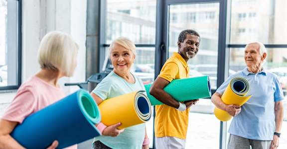 a group of people holding yoga mats in a gym  at 55+ FountainGlen Terra Vista, Rancho Cucamonga, CA, 91730