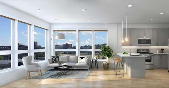 A modern kitchen with a dining table and chairs is adjacent to a living room with a couch and a coffee table.