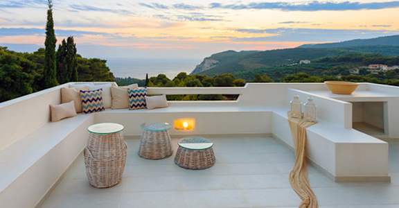 A patio with a table and chairs overlooking a scenic view.