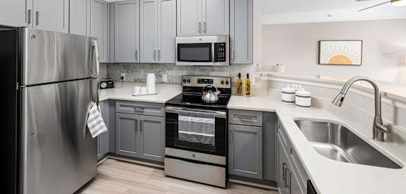 a kitchen with stainless steel appliances and gray cabinets