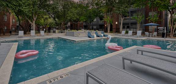 a swimming pool with pink flamingos in it at dusk