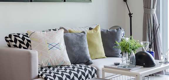 a living room with pillows on a couch and a coffee table