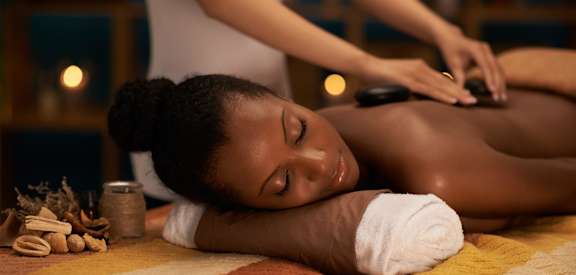 a young child laying on a massage table while a woman is getting a back massage