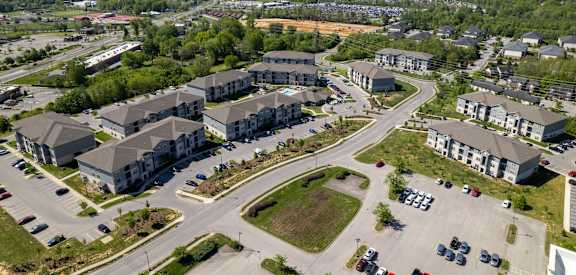 A bird's eye view of a residential area with multiple houses and cars.