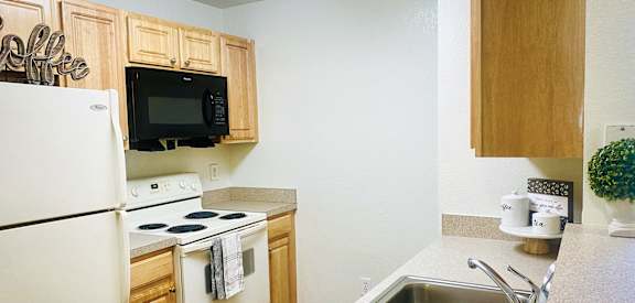 a kitchen with white appliances and wooden cabinets
