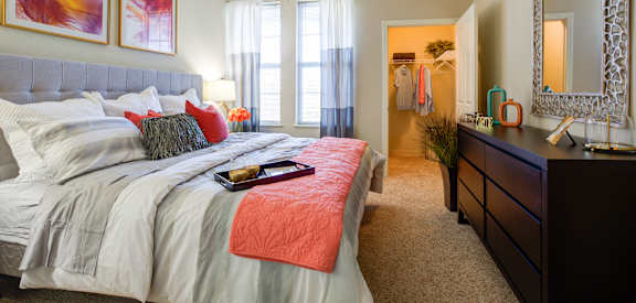 A bedroom with a large bed and a mirror on the wall.