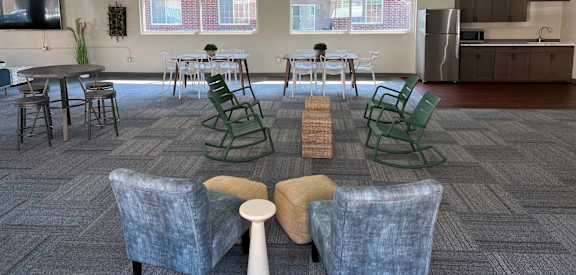 an open room with chairs and tables and a kitchen in the background at Courtyard Apartments, Moorhead, Minnesota