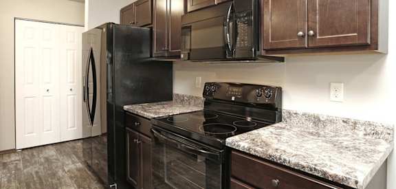 a kitchen with dark wood cabinets and granite countertops