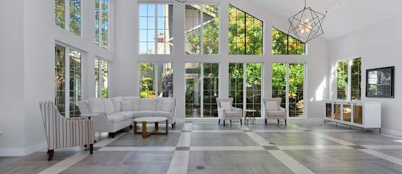 a large living room with large windows and a checkered tile floor