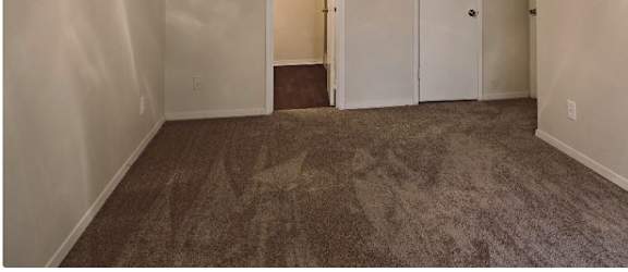 a room with a carpeted floor and a white door
