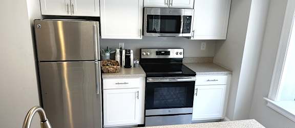 Renovated kitchen with white cabinets and stainless steel appliances