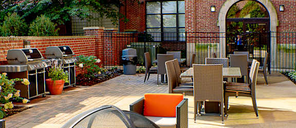 a courtyard with a fire pit and tables and chairs