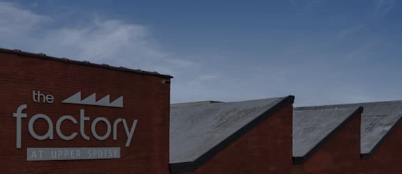 The factory at Upper Spotsy is a red brick building with a sign on the side.