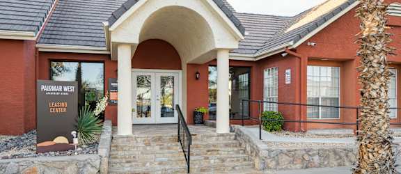the front of a brick building with a stone walkway and steps
